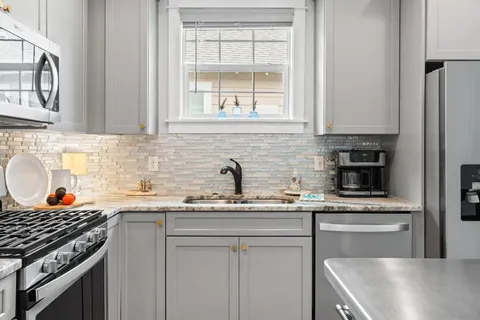 a kitchen with stainless steel appliances granite countertop a sink stove and cabinets