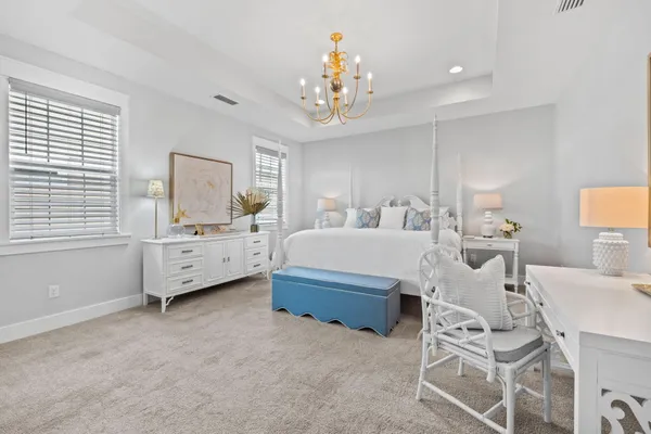 a spacious bedroom with a bed and a chandelier