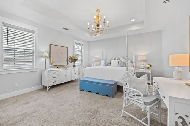 a spacious bedroom with a bed and a chandelier