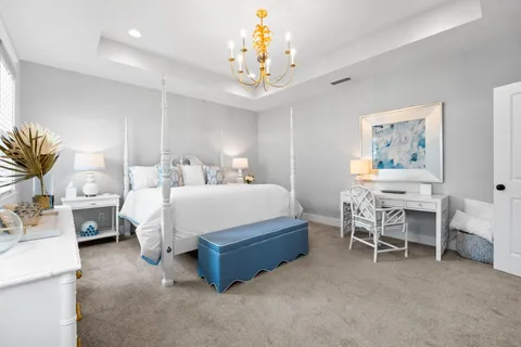 a spacious bedroom with a bed and a chandelier