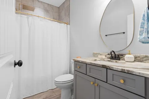 a bathroom with a granite countertop sink and a mirror