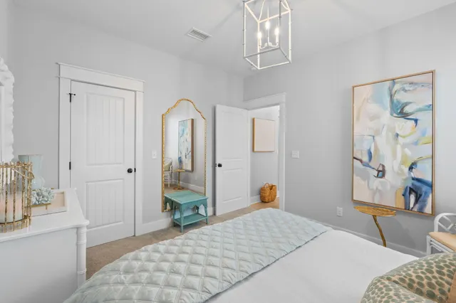 a bedroom with a bed and a chandelier