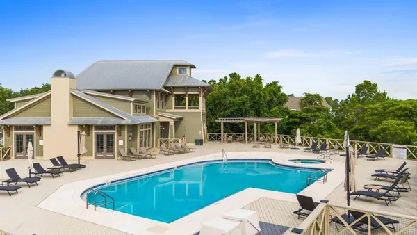 a view of a house with pool and chairs