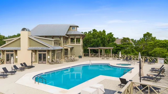 a view of a house with pool and chairs