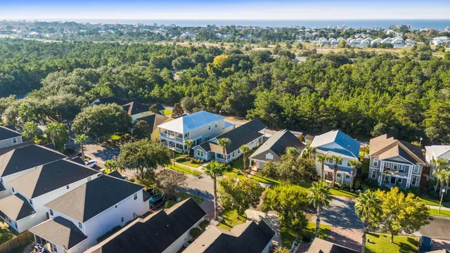 an aerial view of residential houses with outdoor space and trees