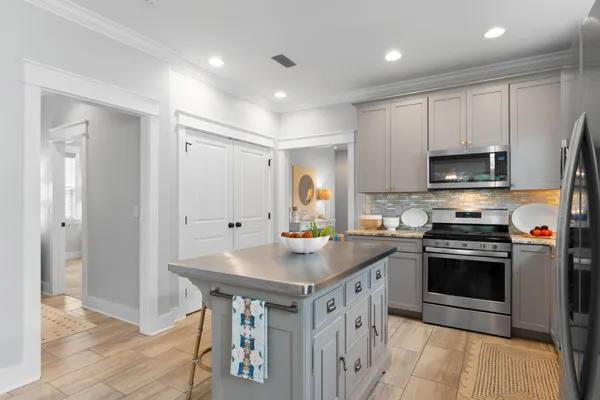 a kitchen with stainless steel appliances granite countertop a stove a sink and a refrigerator with wooden floor