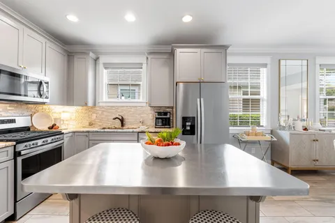 a kitchen with stainless steel appliances granite countertop a sink stove and refrigerator