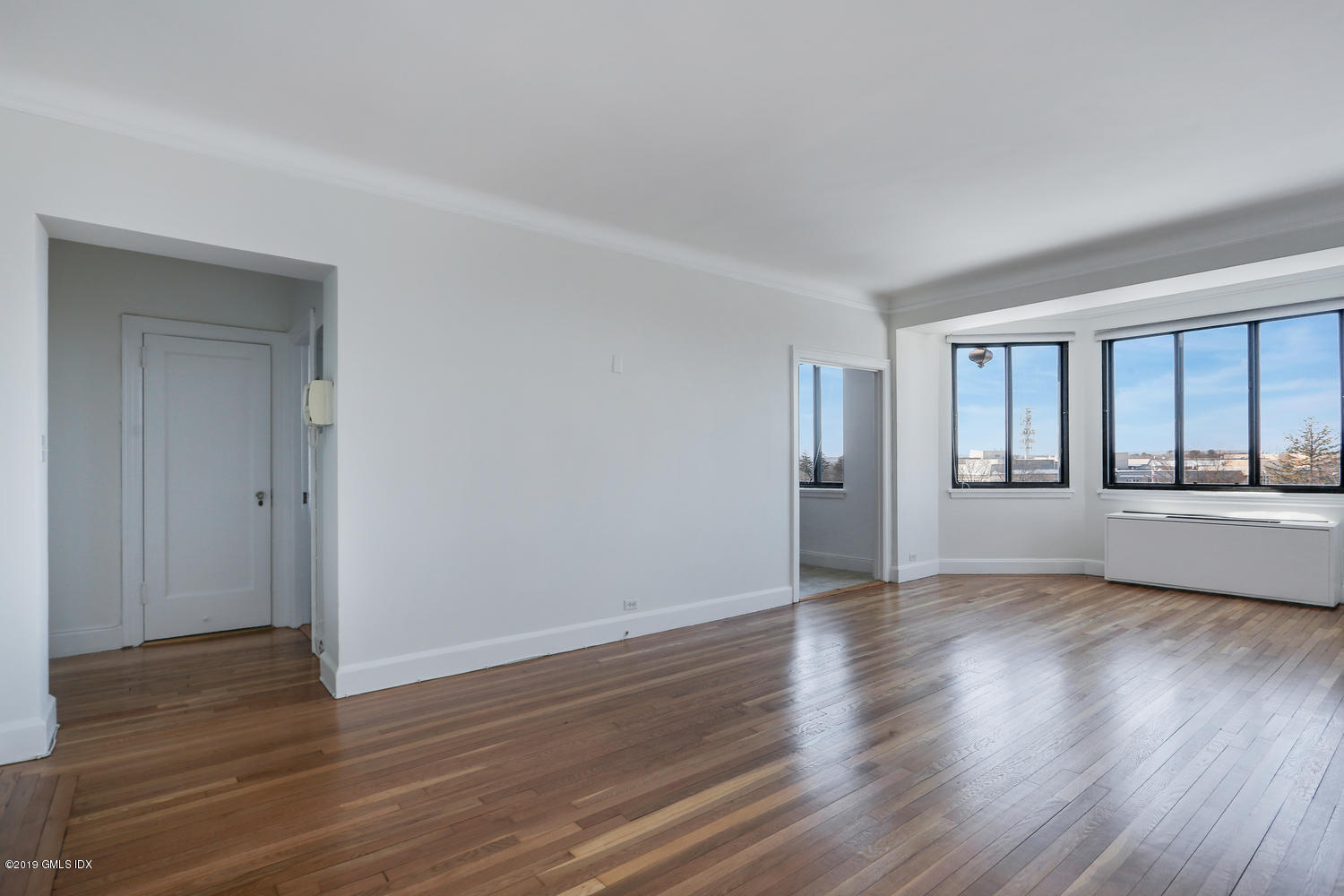 47 Lafayette Place, Unit 5D Greenwich, CT 06830 - Photo 3 of 11 a view of an empty room with wooden floor and a window