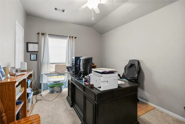 a view of a workspace with furniture and a window