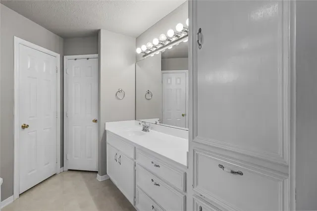 a spacious bathroom with a double vanity sink a large mirror and shower