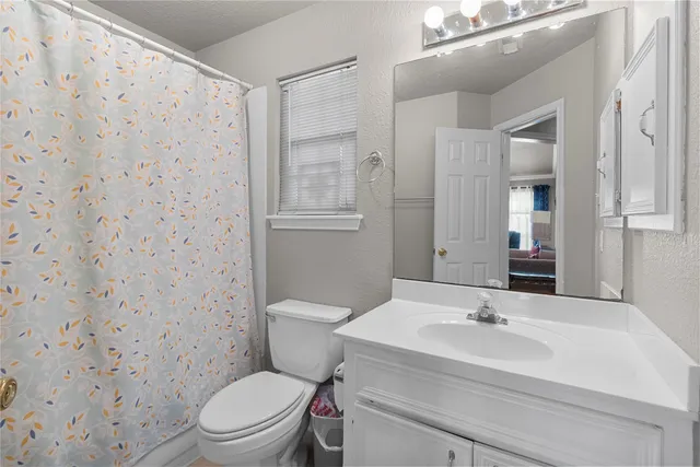 a bathroom with a sink toilet vanity and shower