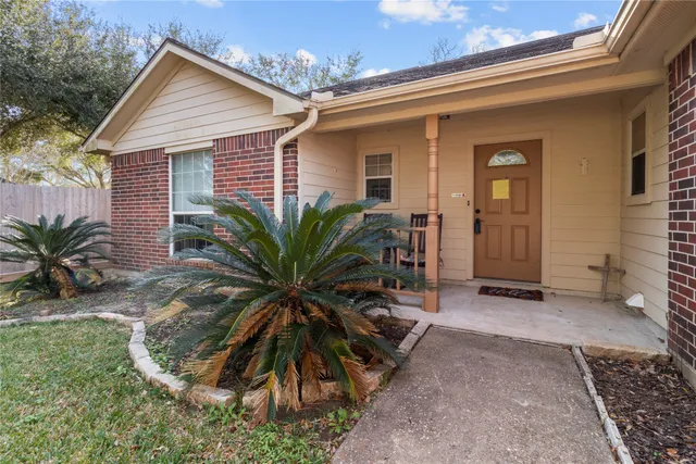 a view of a house with a yard and potted plants