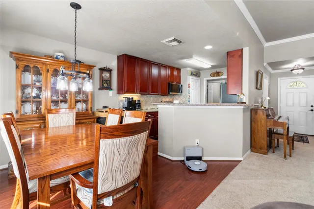 a kitchen with granite countertop a table chairs stove and wooden floor