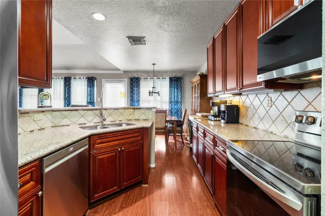 a kitchen with stainless steel appliances granite countertop a stove and a sink