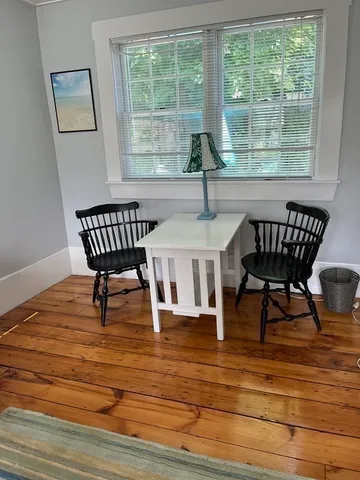 a view of a dining room with furniture a chandelier and wooden floor