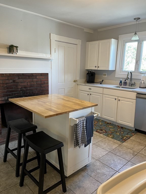 21 Blaney Street, Unit 1 Swampscott, MA 01907 - Photo 7 of 24 a kitchen with a table chairs sink and cabinets