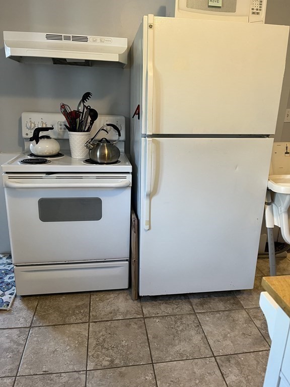 21 Blaney Street, Unit 1 Swampscott, MA 01907 - Photo 8 of 24 a white refrigerator freezer sitting inside of a kitchen with stainless steel appliances