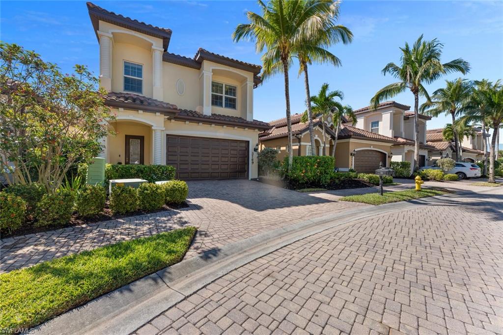 5769 Mango Circle Naples, FL 34110 - Photo 15 of 42 a front view of a house with garden and trees