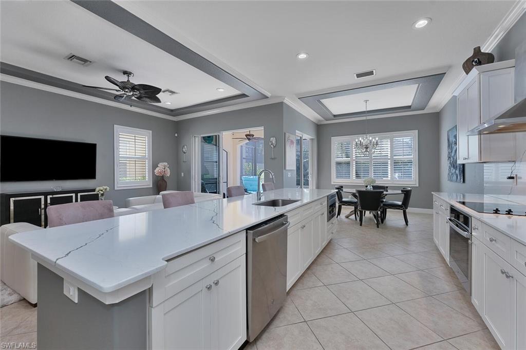 5769 Mango Circle Naples, FL 34110 - Photo 2 of 42 a large kitchen with kitchen island a large counter top space appliances and cabinets