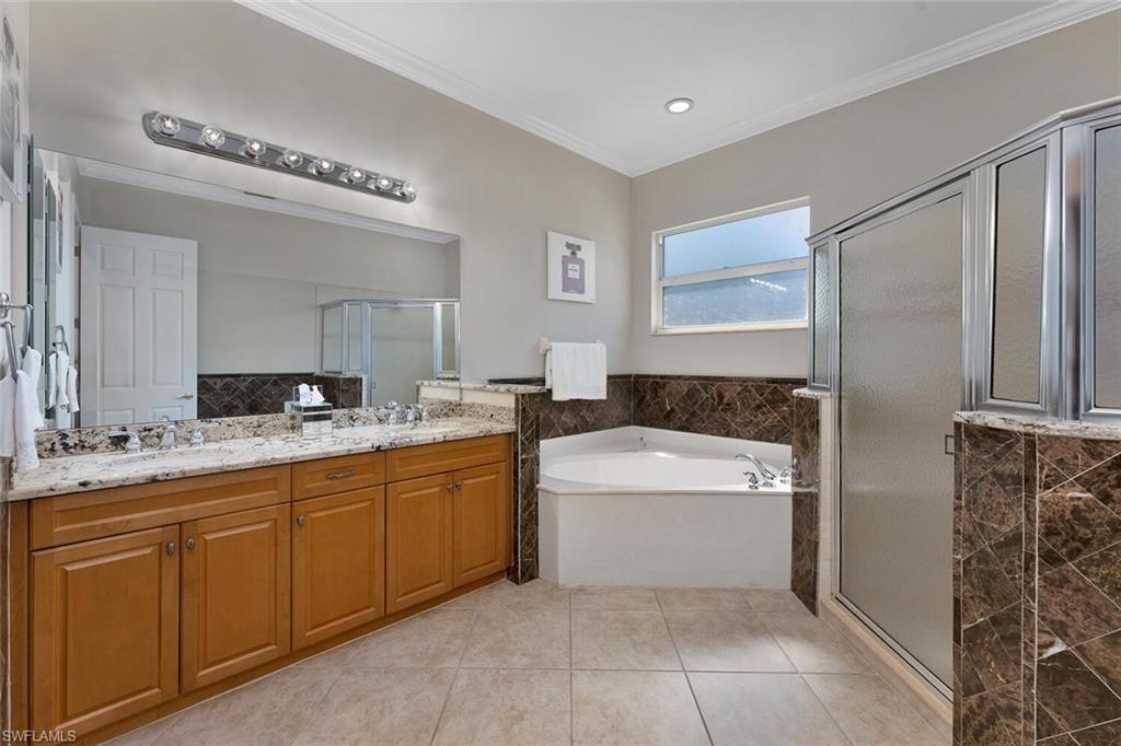 5769 Mango Circle Naples, FL 34110 - Photo 6 of 42 a bathroom with a tub a sink and a mirror