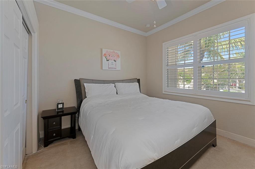 5769 Mango Circle Naples, FL 34110 - Photo 10 of 42 a large bed sitting in a bedroom next to a window