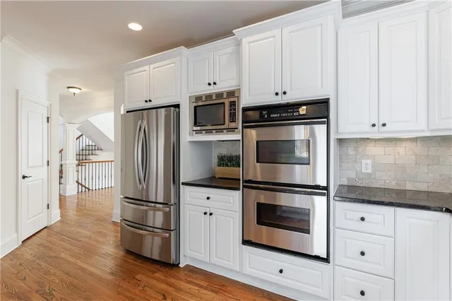 a view of an empty room with wooden floor fireplace and a window