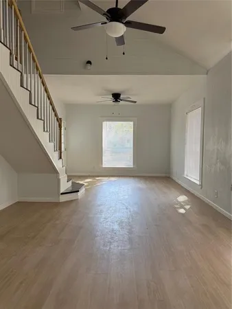 an empty room with windows and fan