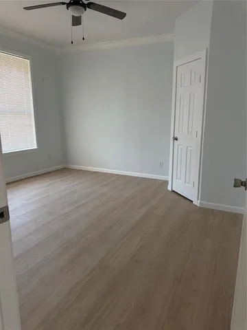 an empty room with a ceiling fan and window
