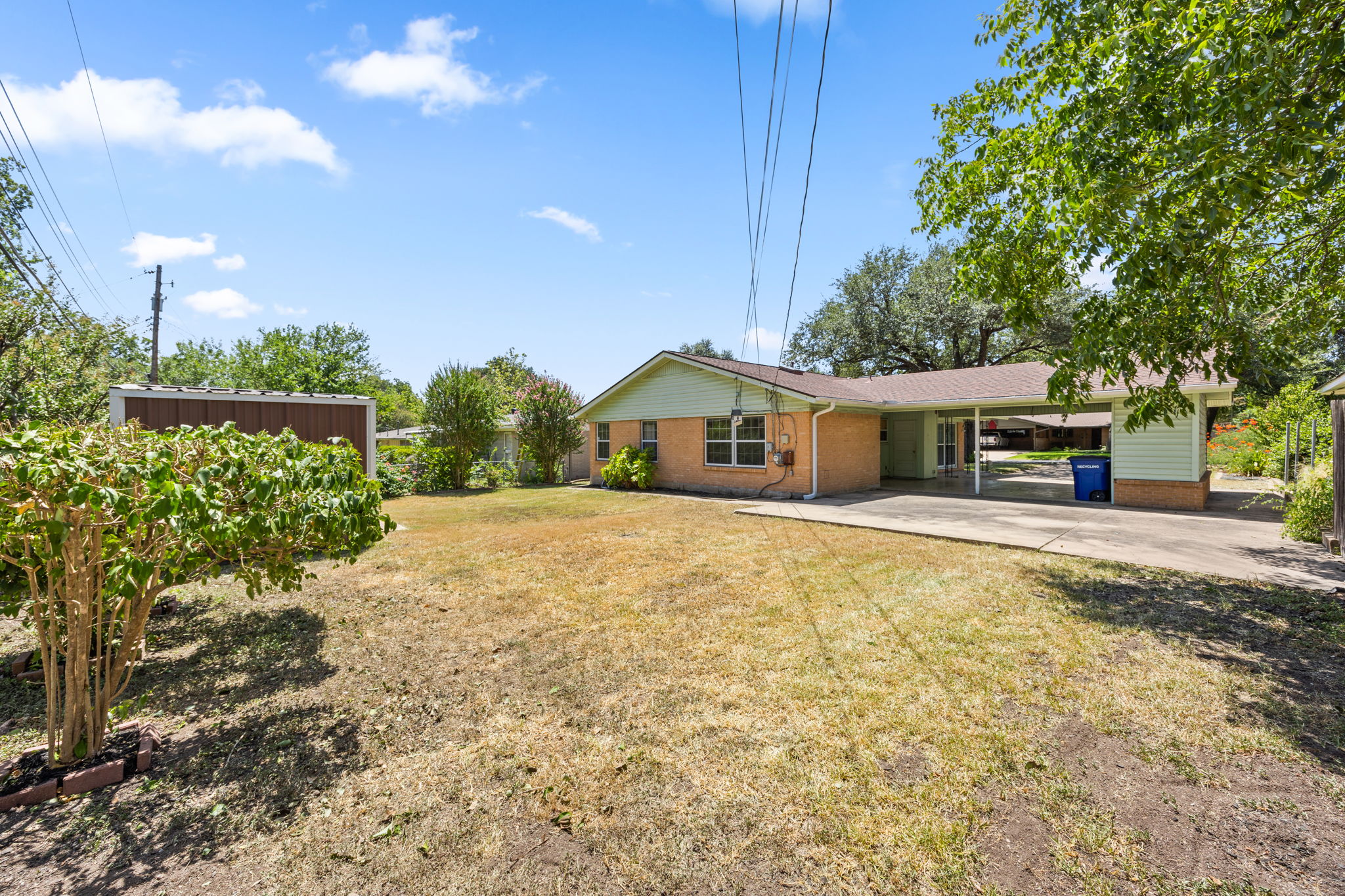 1702 Ridgemont Drive Austin, TX 78723 - Photo 17 of 18 A spacious lawn highlights the back of this single-story brick home featuring a concrete patio.