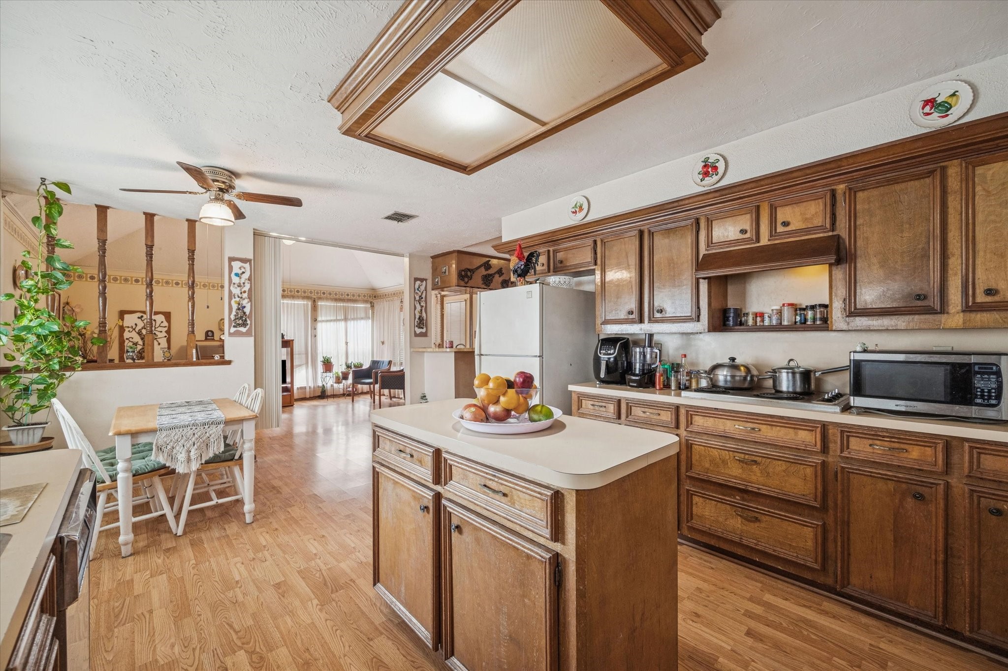 15427 Rio Plaza Drive Houston, TX 77083 - Photo 7 of 16 a kitchen with a refrigerator a stove a dining table and chairs with wooden floor