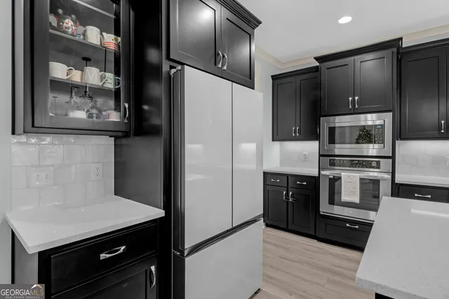 a kitchen with stainless steel appliances cabinets and wooden floor