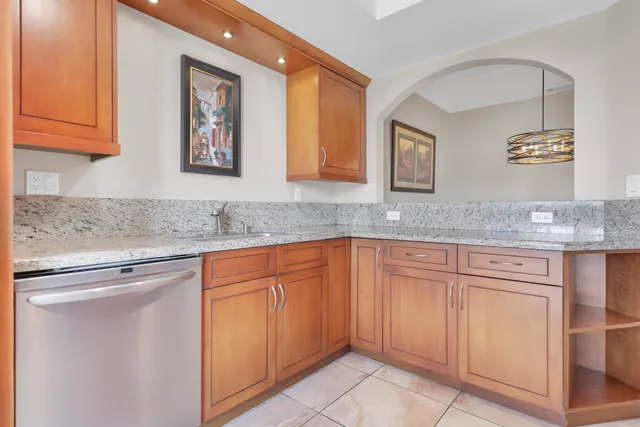a kitchen with granite countertop white cabinets and stainless steel appliances