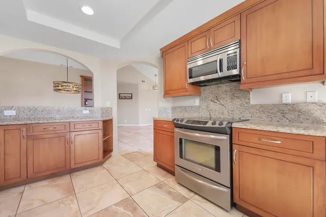 a kitchen with granite countertop cabinets stainless steel appliances and a sink