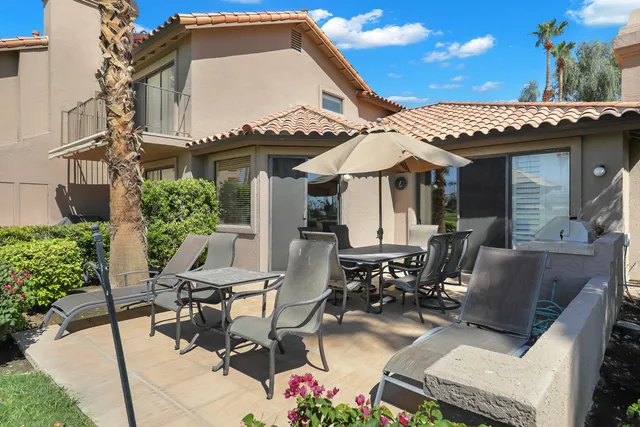 a view of a patio with table and chairs potted plants