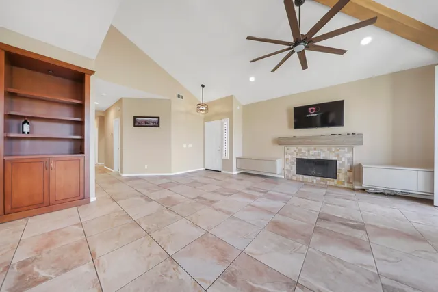 a view of a livingroom with a fireplace cabinet and windows