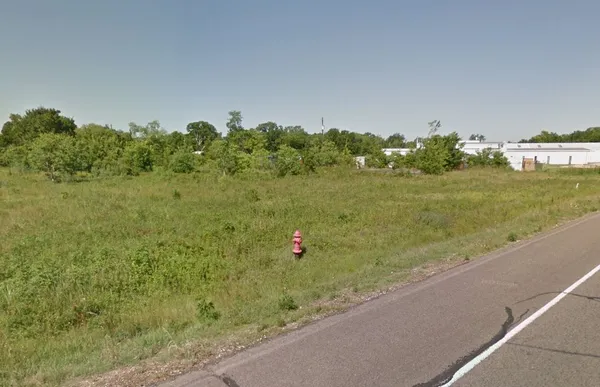 a view of a field with an trees in front of it