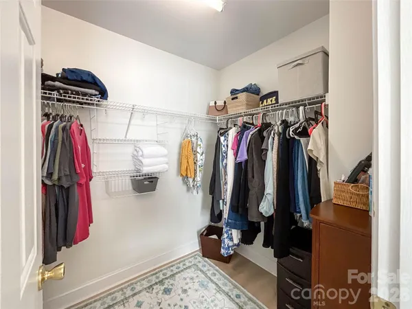 a view of walk in closet with clothes