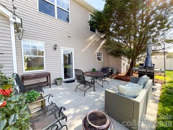 a view of a patio with couches table and chairs and potted plants