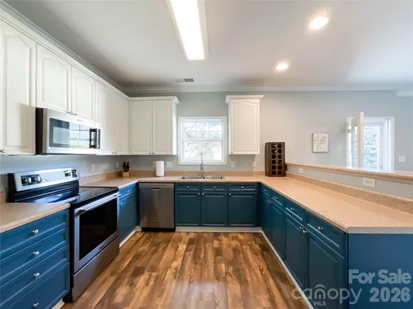 a large kitchen with stainless steel appliances granite countertop a sink and cabinets