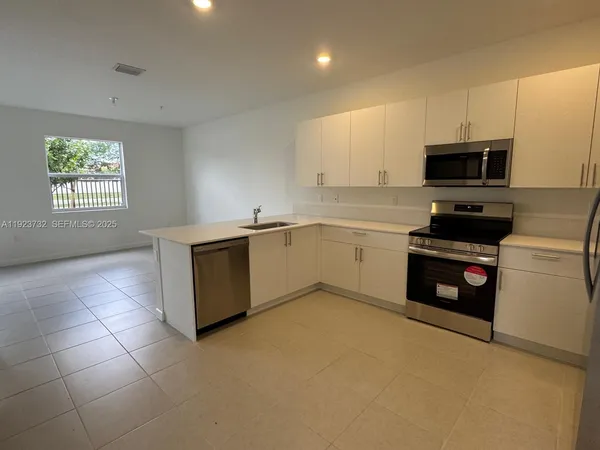 a kitchen with a sink a stove and cabinets