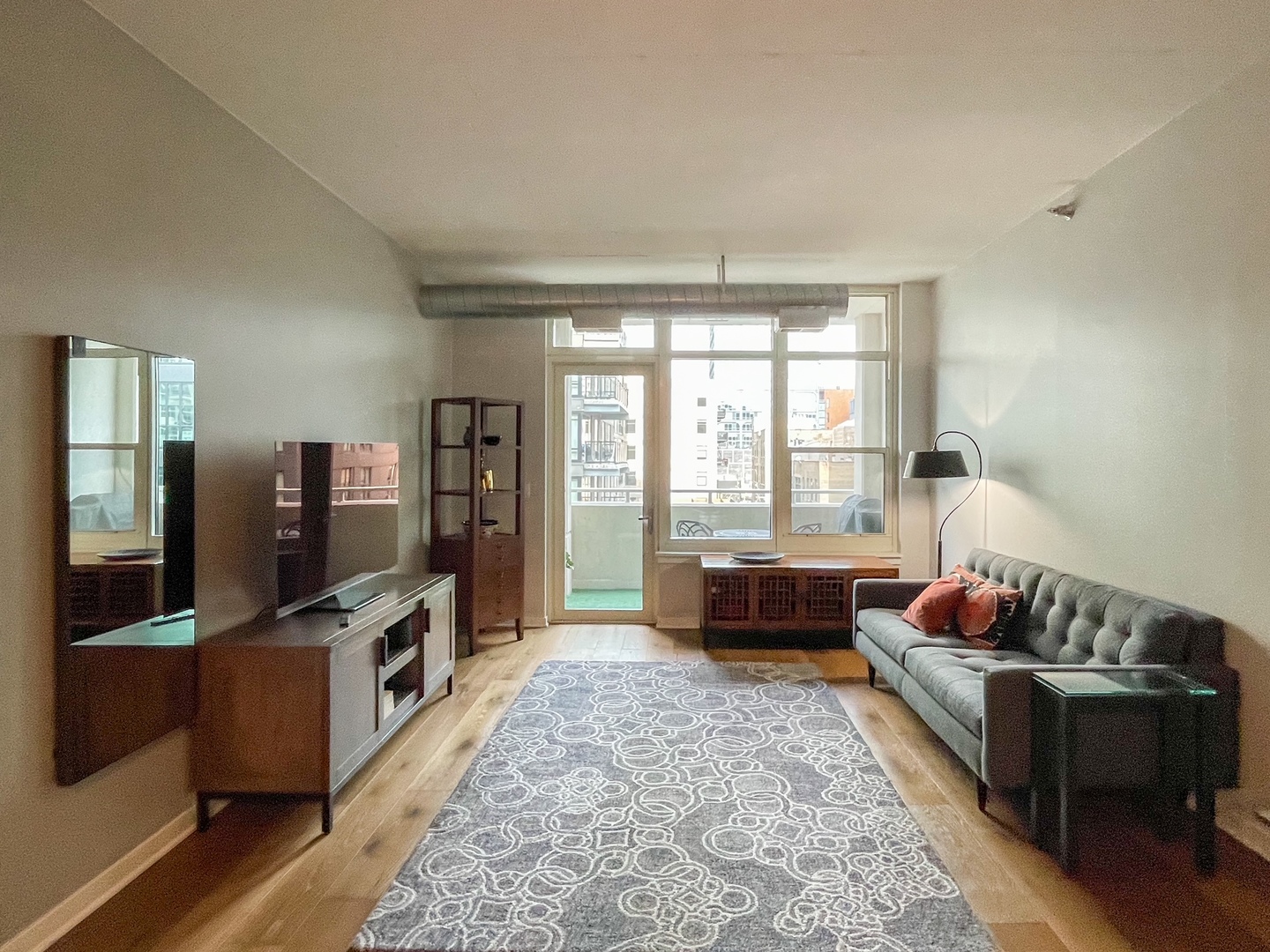 909 West Washington Boulevard, Unit 510 Chicago, IL 60607 - Photo 5 of 16 a living room with furniture a flat screen tv and a couch