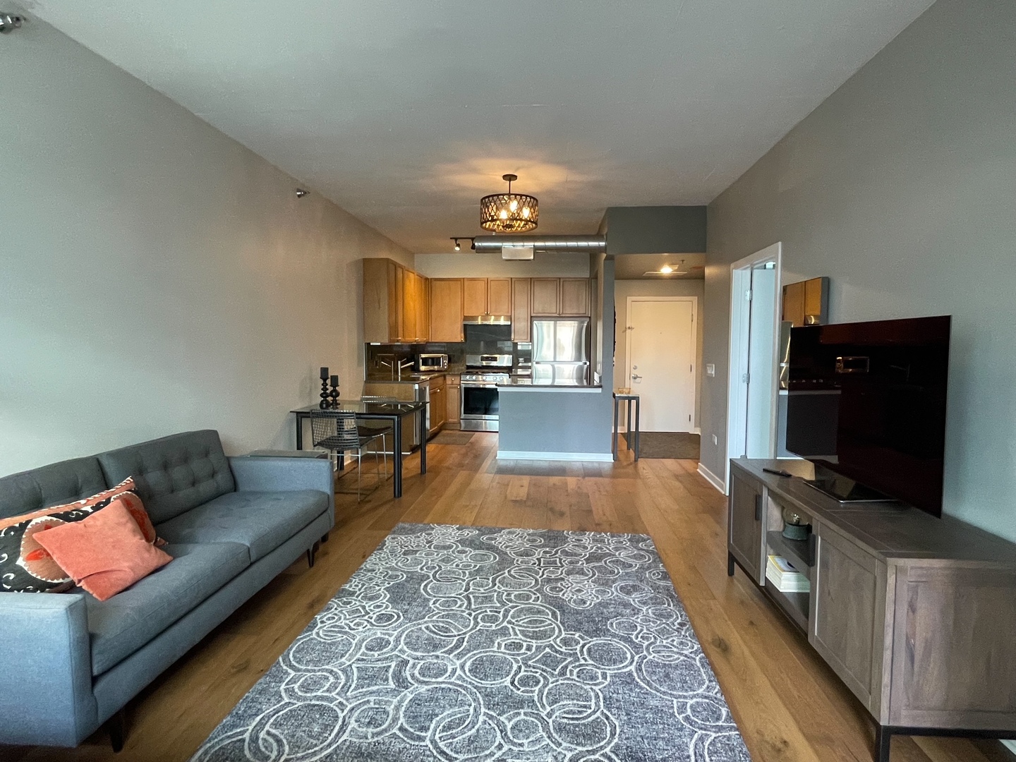 909 West Washington Boulevard, Unit 510 Chicago, IL 60607 - Photo 6 of 16 a living room with furniture and a flat screen tv