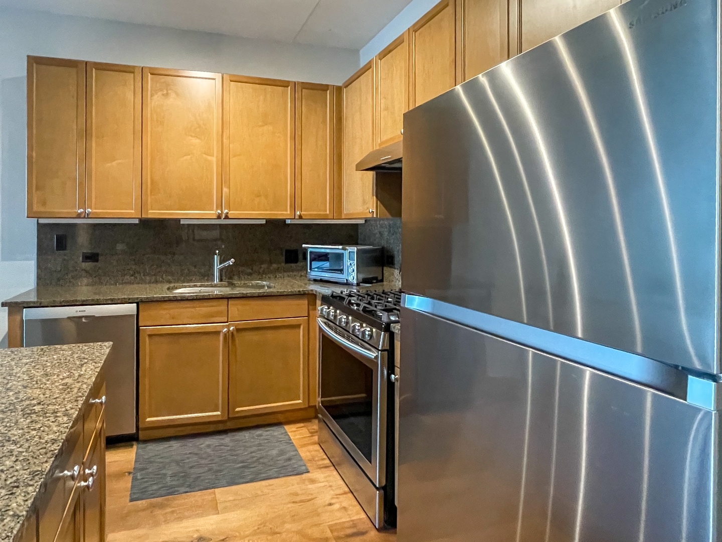 909 West Washington Boulevard, Unit 510 Chicago, IL 60607 - Photo 8 of 16 a kitchen with granite countertop a refrigerator stove and sink