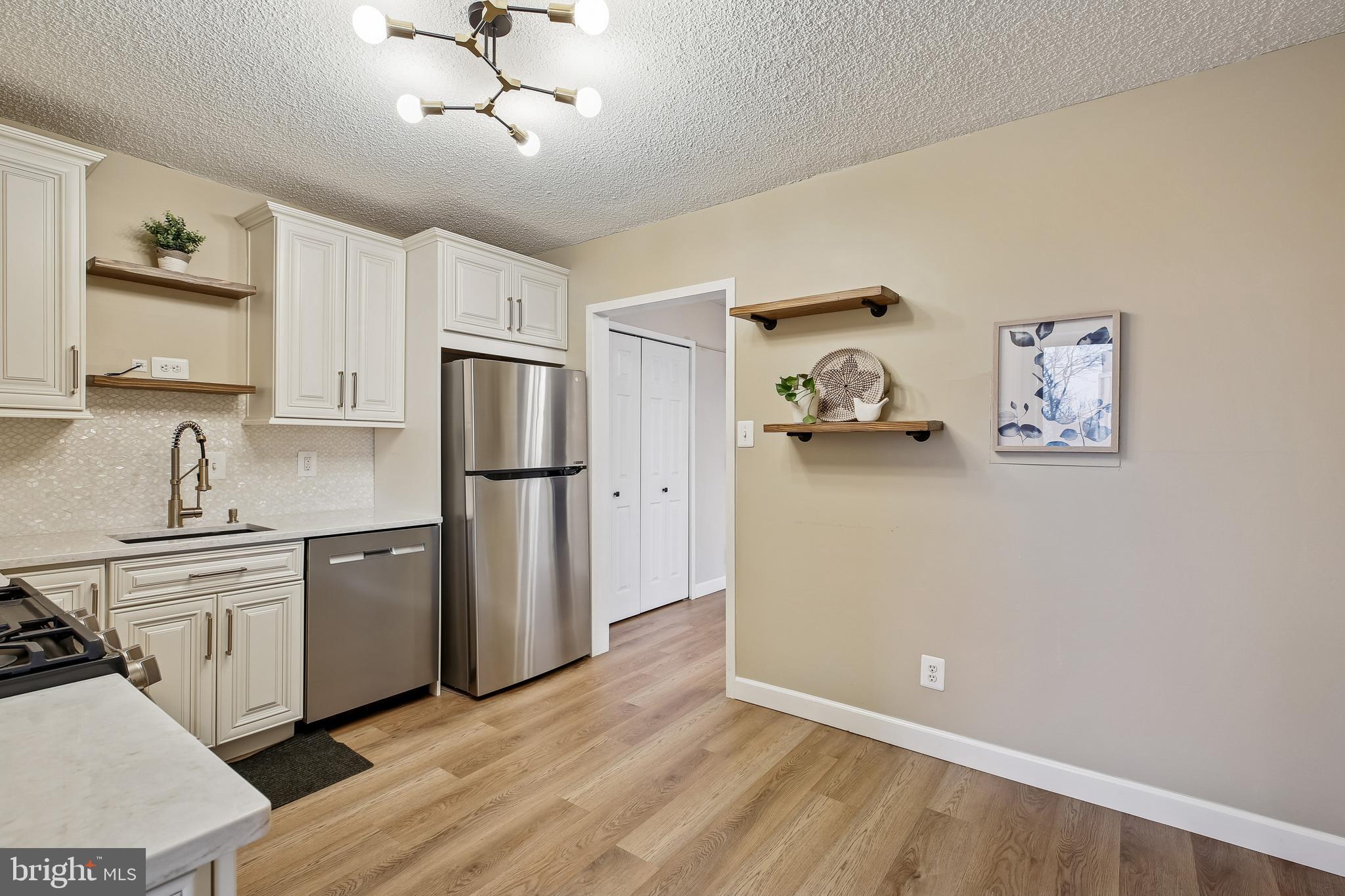 5225 Pooks Hill Road, Unit 629S Bethesda, MD 20814 - Photo 10 of 58 a kitchen with stainless steel appliances granite countertop a refrigerator a stove and white cabinets with wooden floor