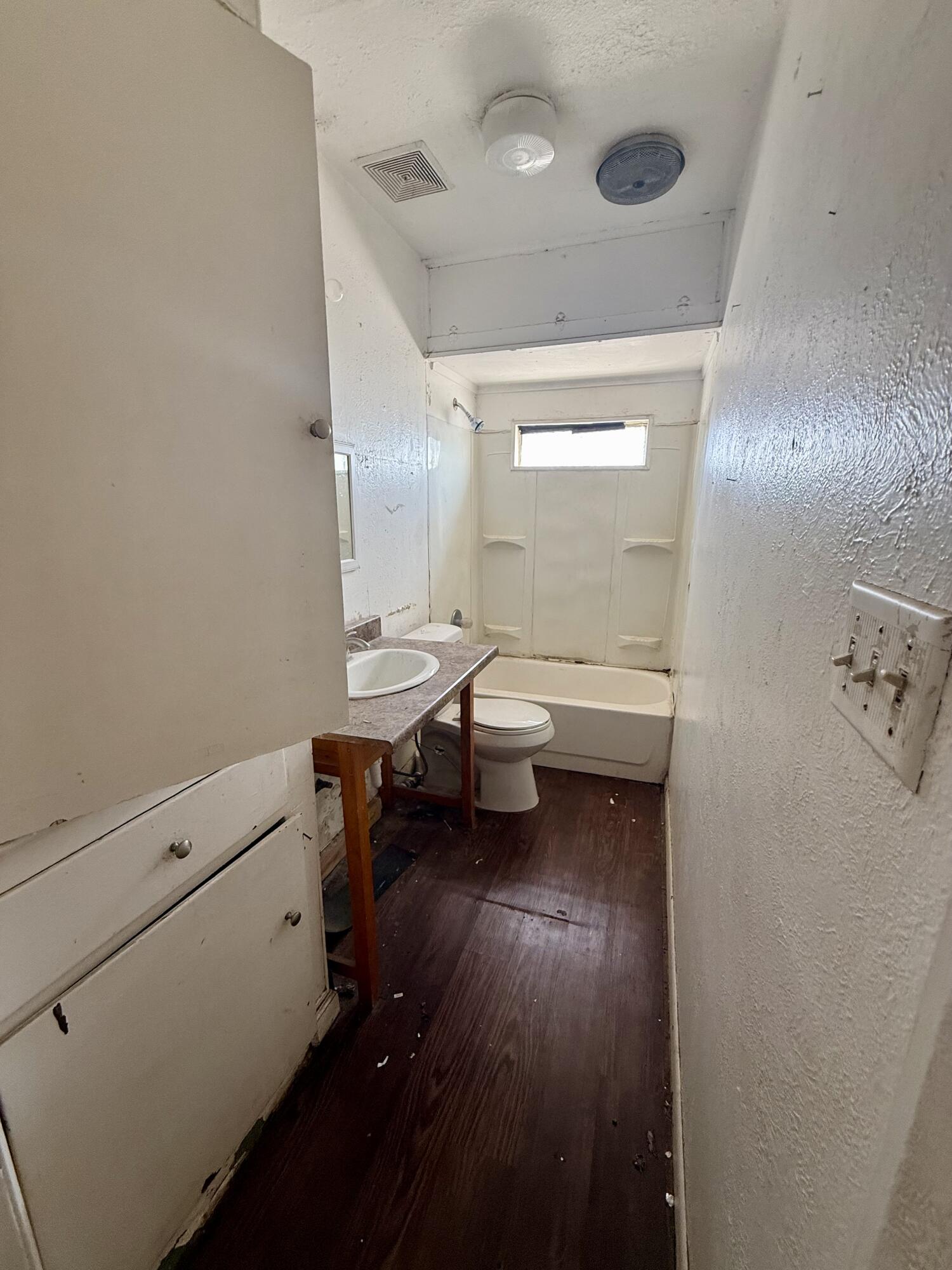 6119 20th Street Lubbock, TX 79407 - Photo 5 of 9 a bathroom with a toilet a sink and mirror