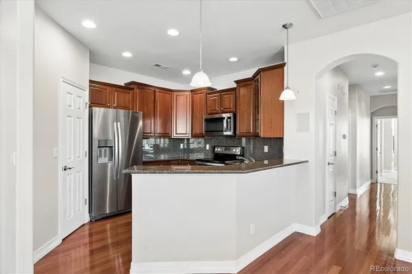a kitchen with stainless steel appliances a refrigerator and a stove top oven