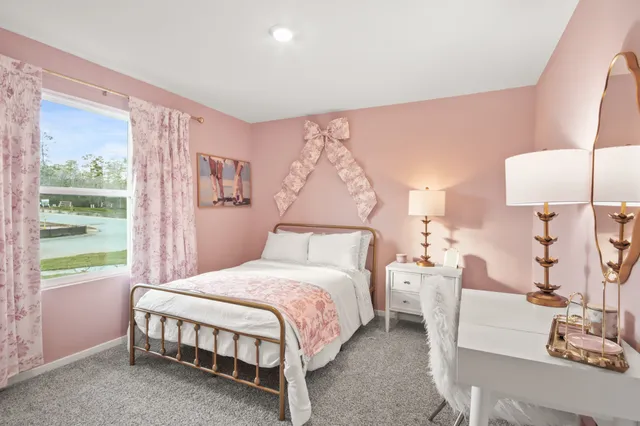 a bedroom with a bed lamp and a large window