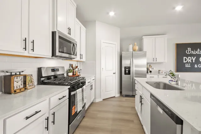 a kitchen with stainless steel appliances granite countertop a sink stove and refrigerator