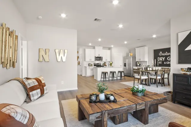 a living room with furniture kitchen view and a table