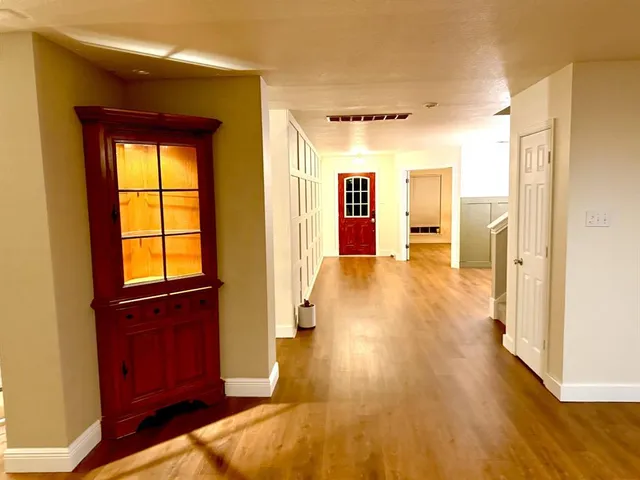 a view of hallway with livingroom and wooden floor